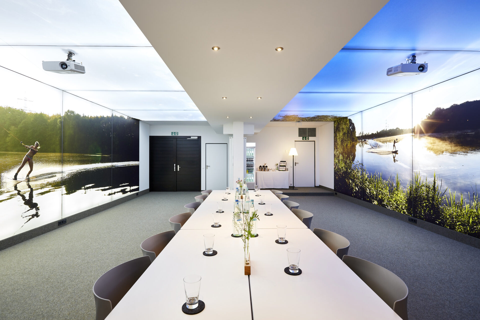 Blick in den Tagungsraum bei Block-Bestuhlung. An den Wänden dekorative Lichtelemente mit Wasserski Motiv