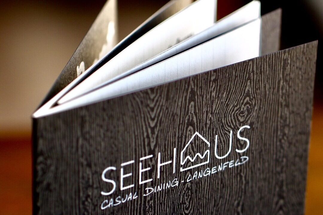 Schwarze Speisekarte mit weißem Seehaus Lagenfeld Logo