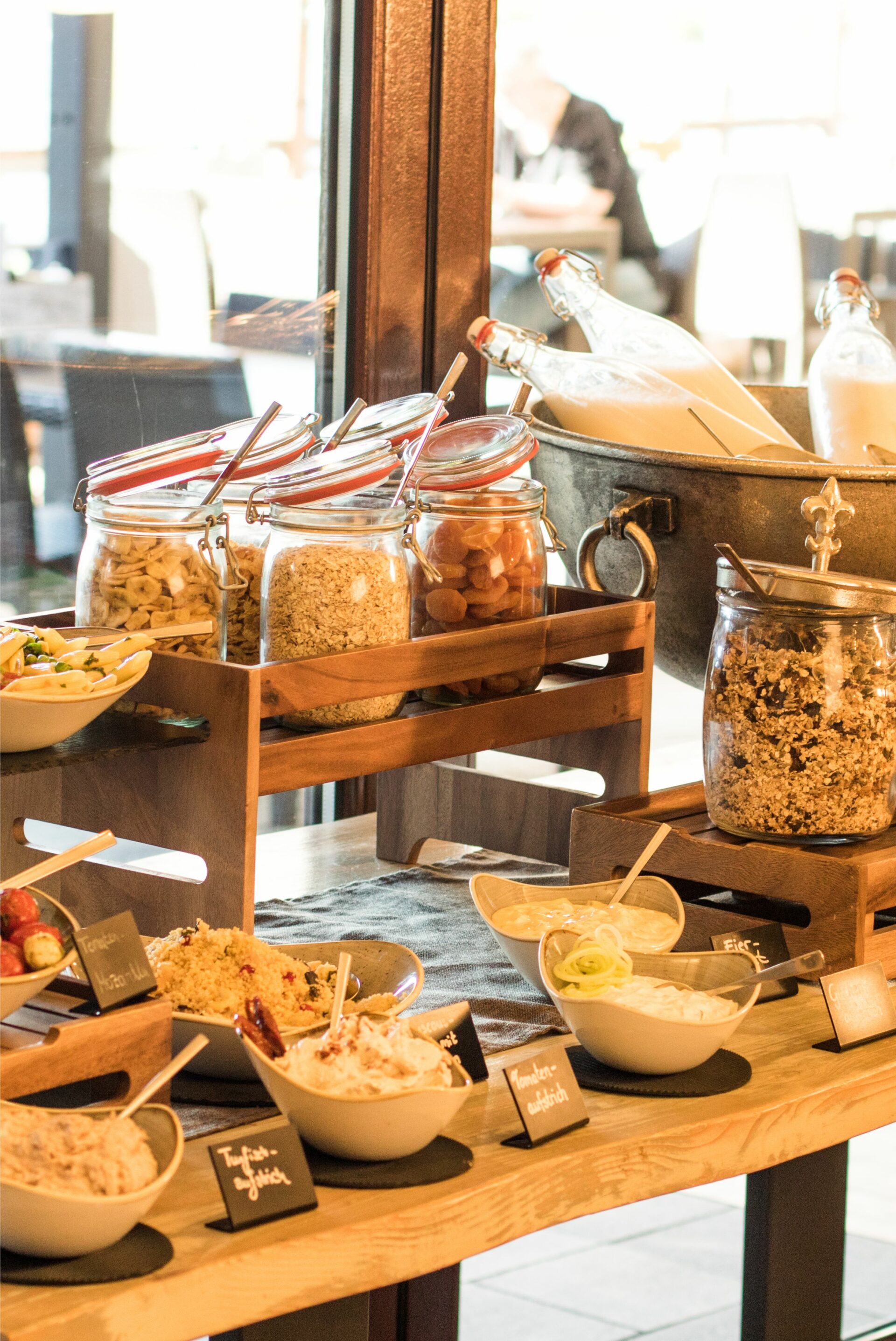 Nahaufnahme der Müsli-Bar beim Frühstücksbuffet mit verschiedenen Müslizutaten und Joghurt