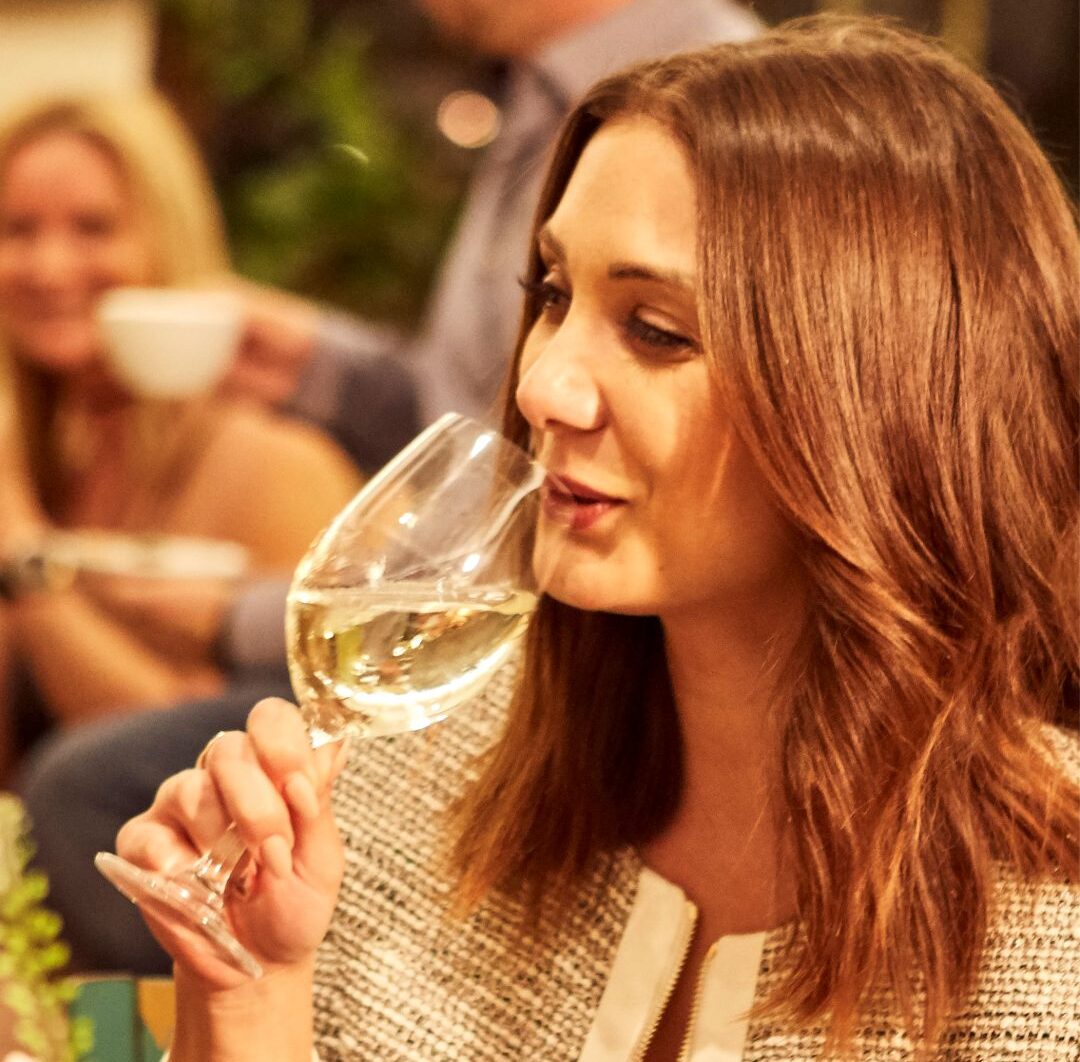 Frau nippt an einem Glas Weiswein